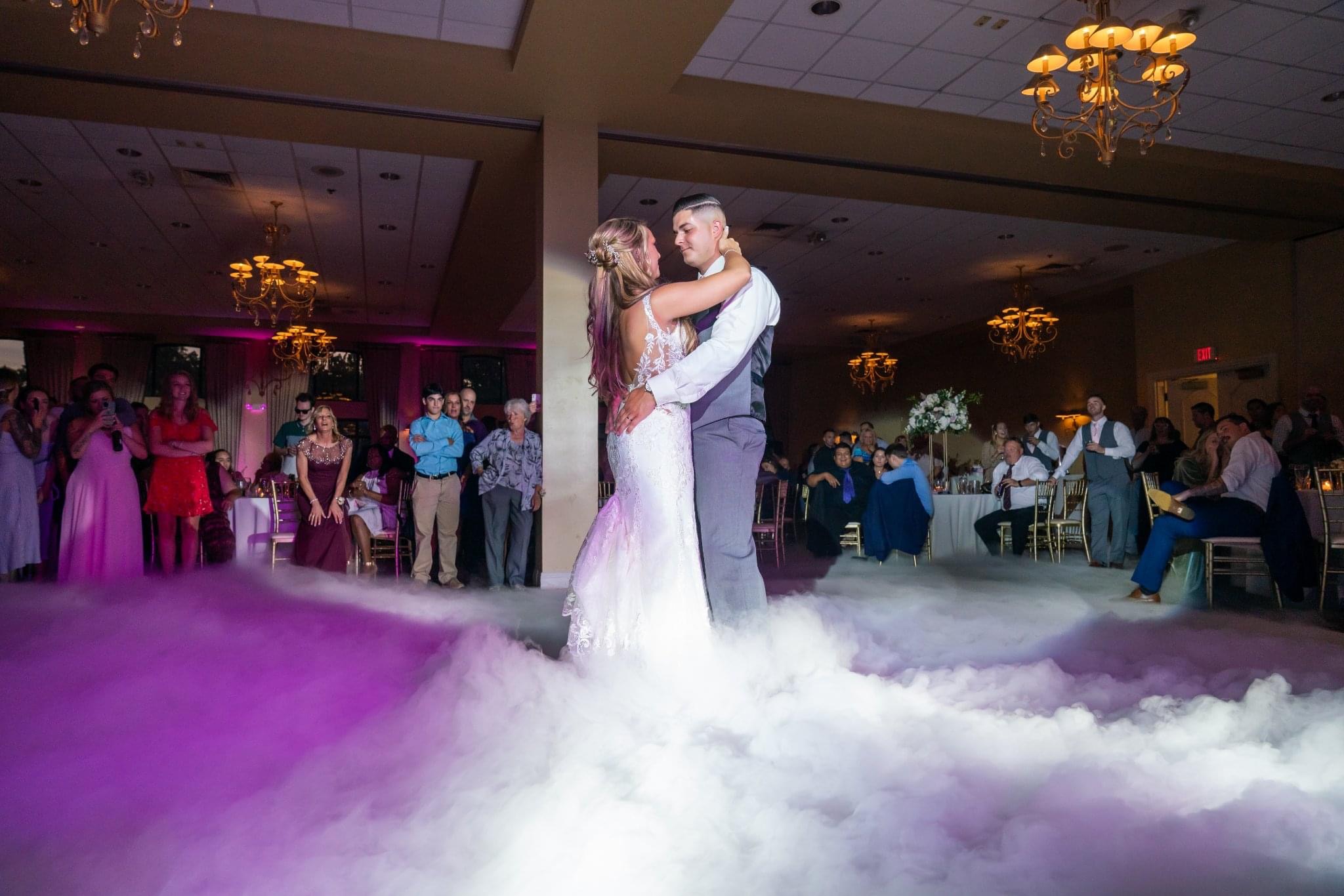 Bride and groom dancing on a cloud with guests watching